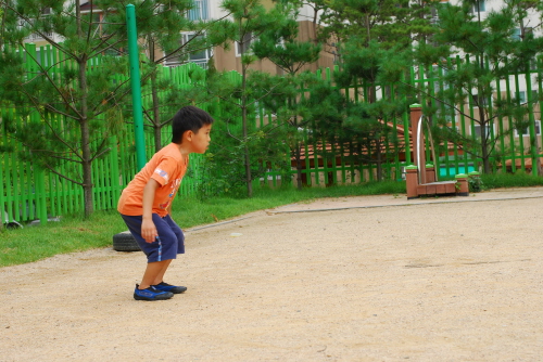 꼬마아이가 진지하게 공을 쳐다보고 있다 